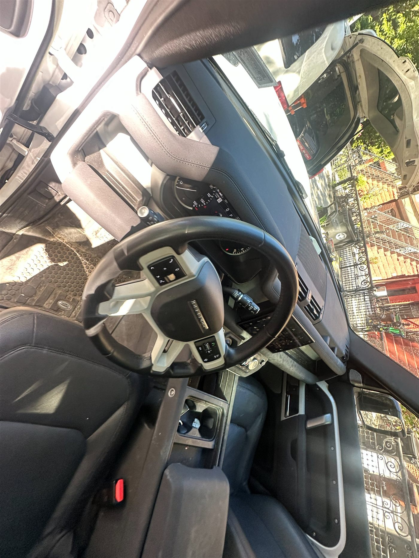 Land Rover Defender interior before deep clean — muddy floor mat and dusty dash