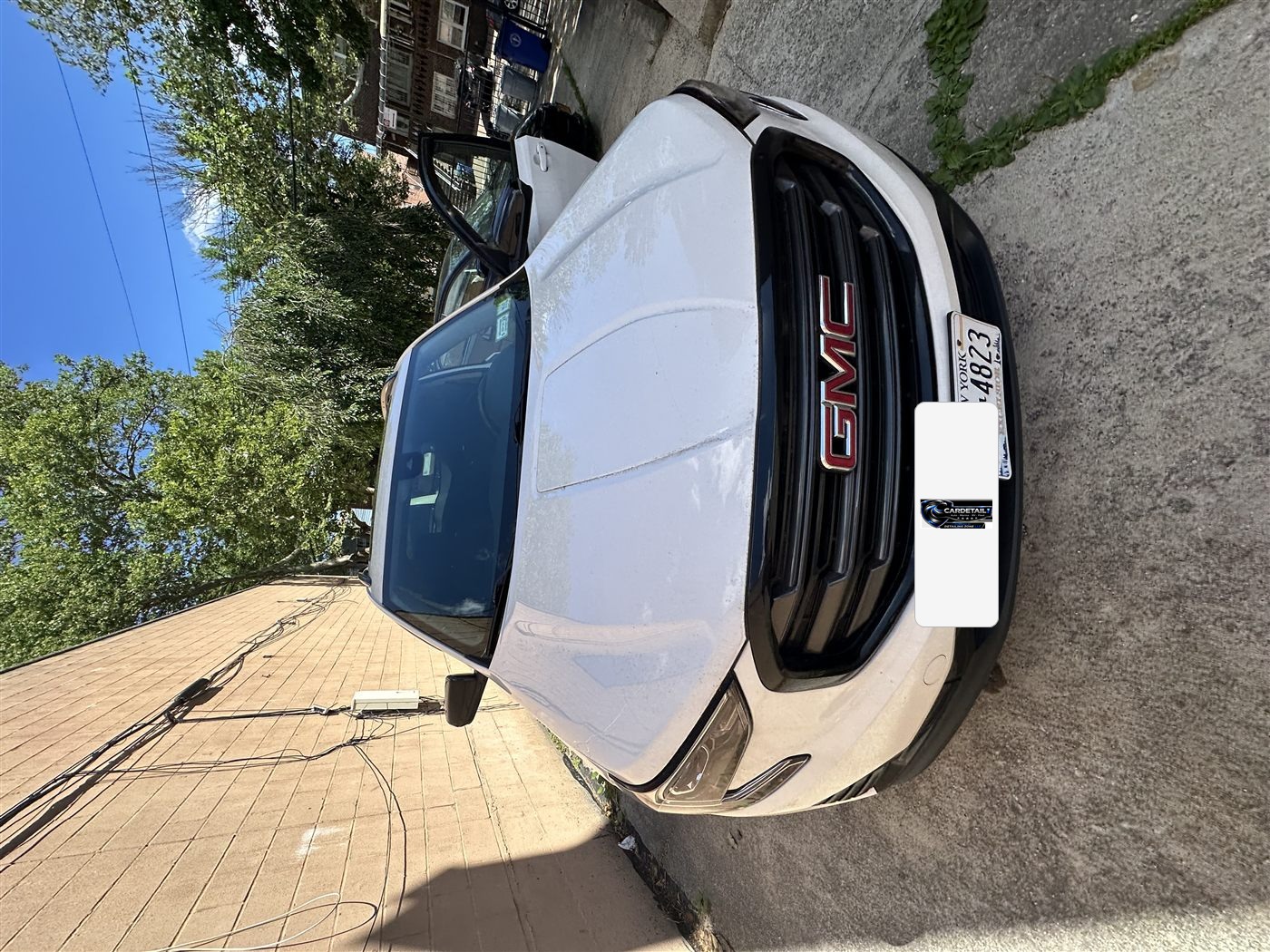 GMC Terrain exterior before mobile detailing — road film on white paint and dusty grille