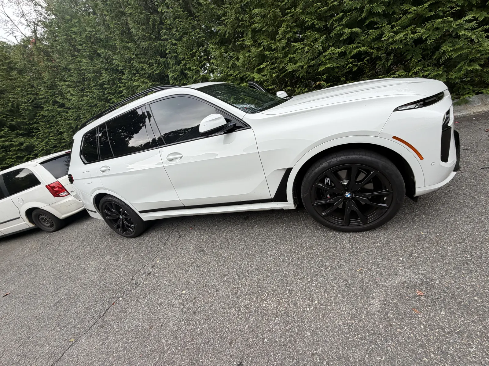White BMW X7 side view with dark wheels