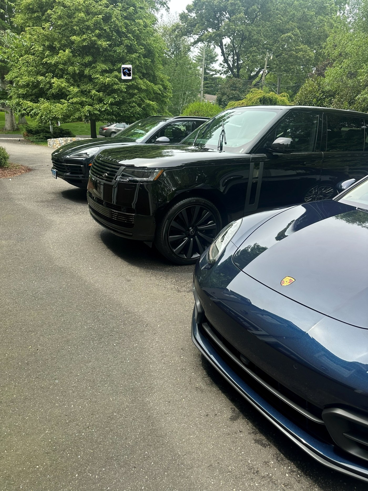 Two Porsches and Range Rover after multi-vehicle premium detail — three luxury SUVs lined up in a driveway with deep gloss finish
